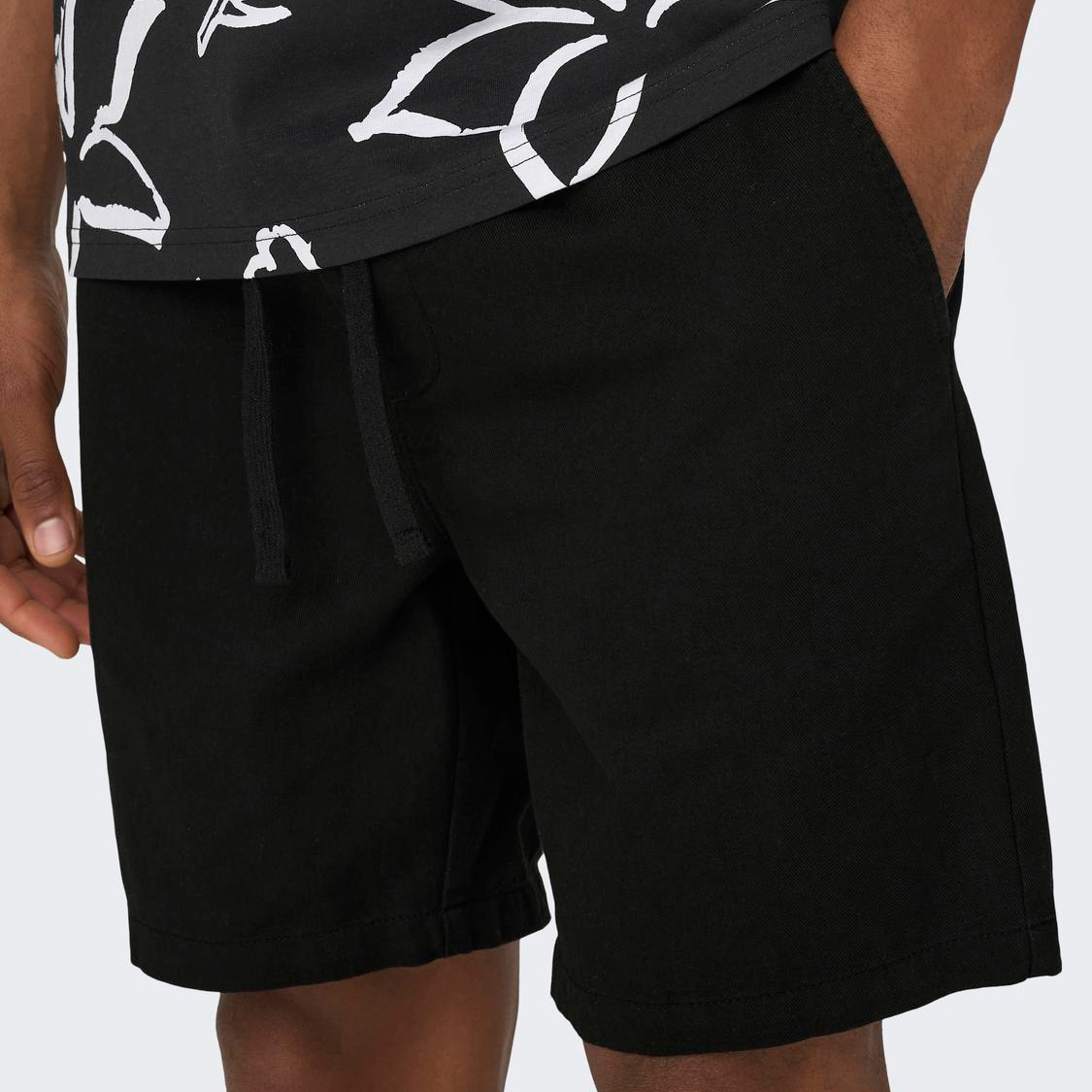 Calções pretos de tecido liso com cordão na cintura