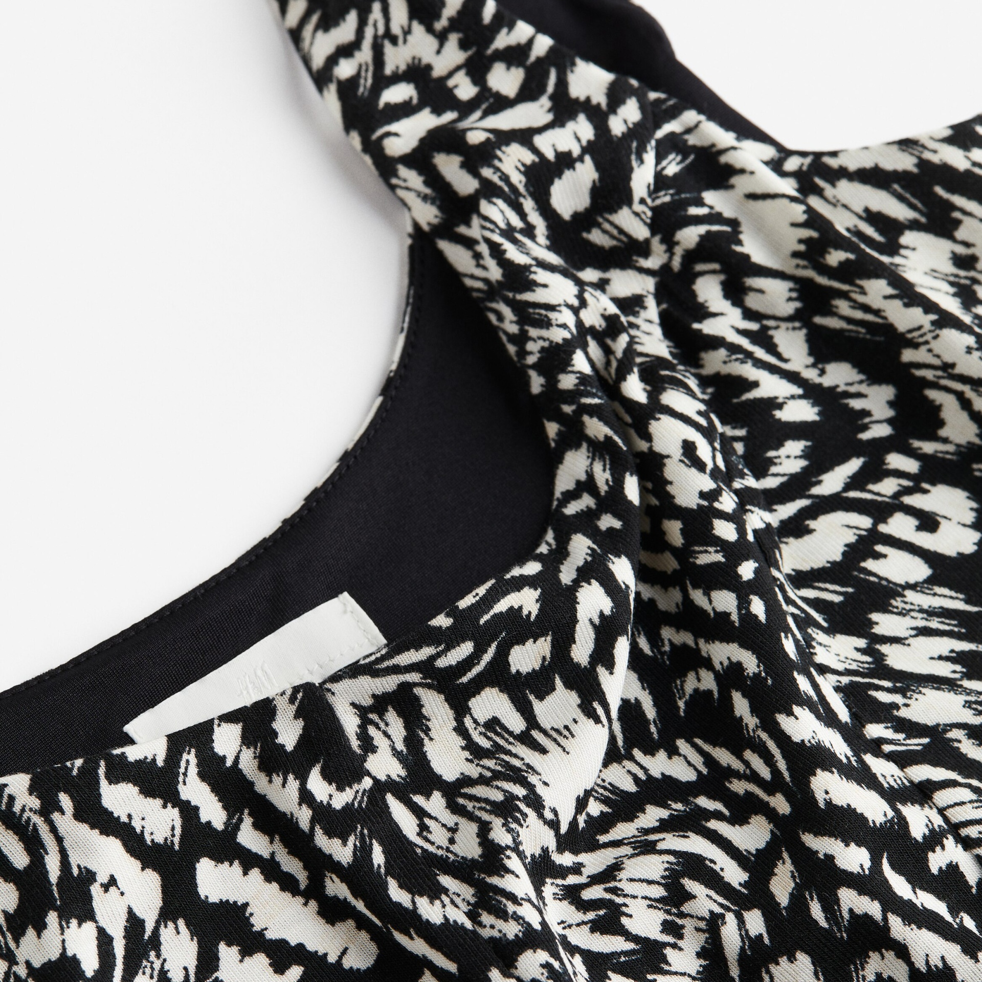 Peça de roupa com padrão animal preto e branco e decote redondo