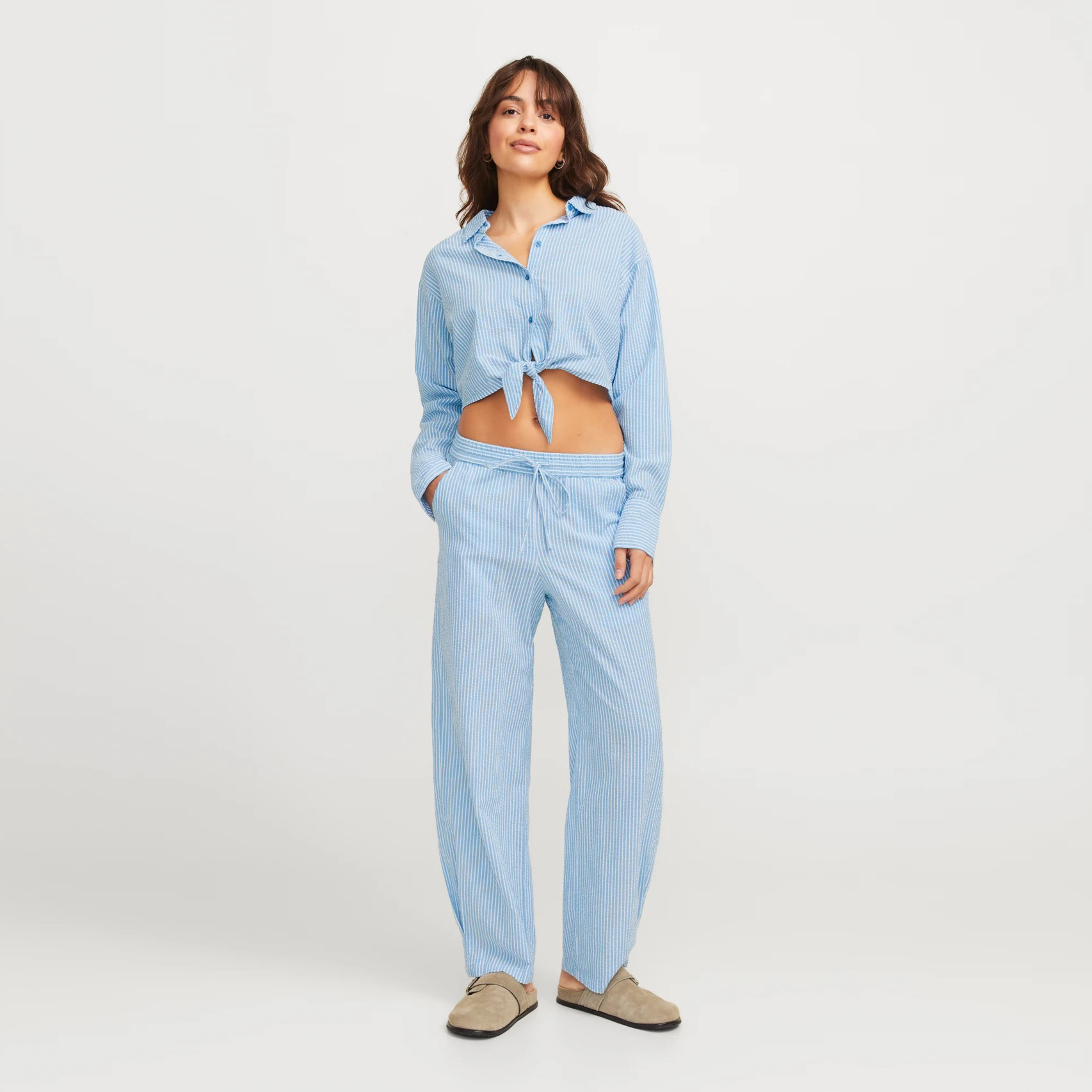 Conjunto pijama azul claro com riscas brancas, camisa com nó frontal e calças largas