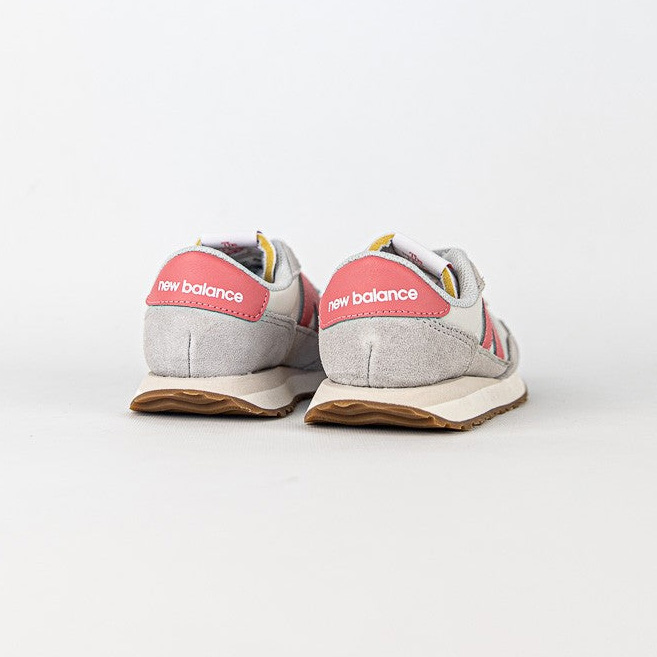 Ténis New Balance cinza e rosa vistos de trás