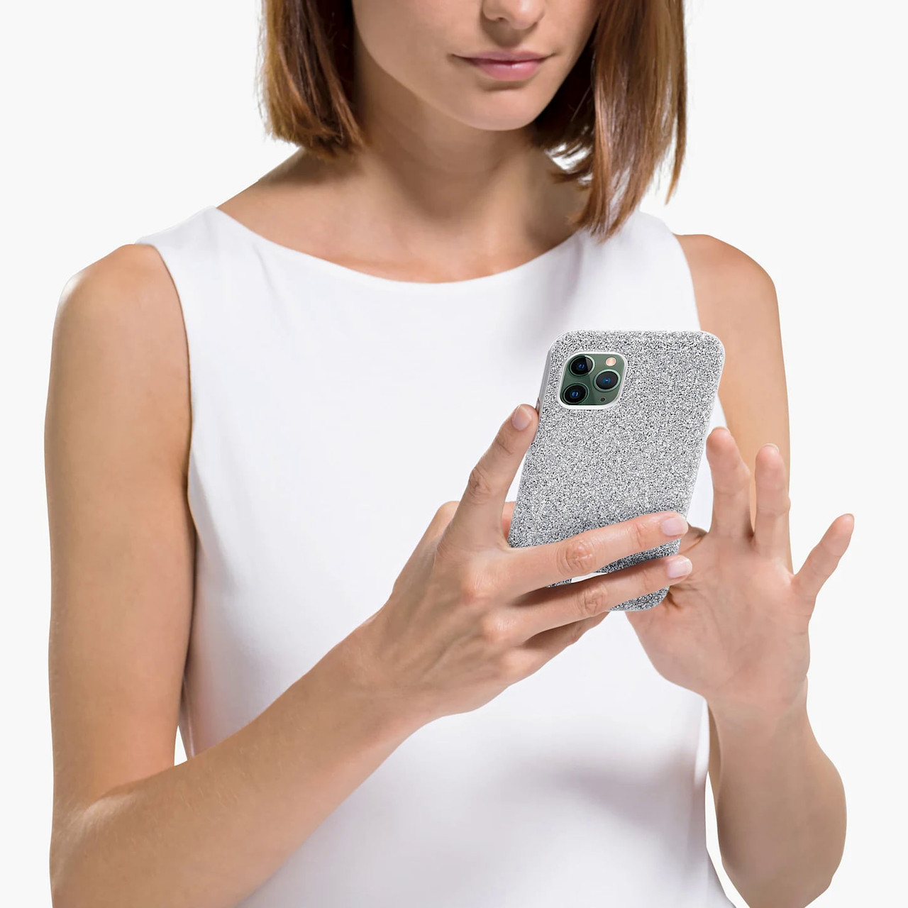 Mulher com blusa branca segura telemóvel com capa cinza texturada