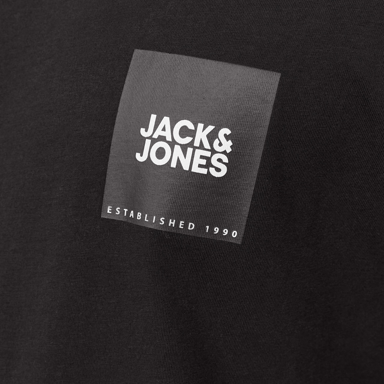 Etiqueta preta com JACK & JONES e ESTABLISHED 1990 em tecido preto