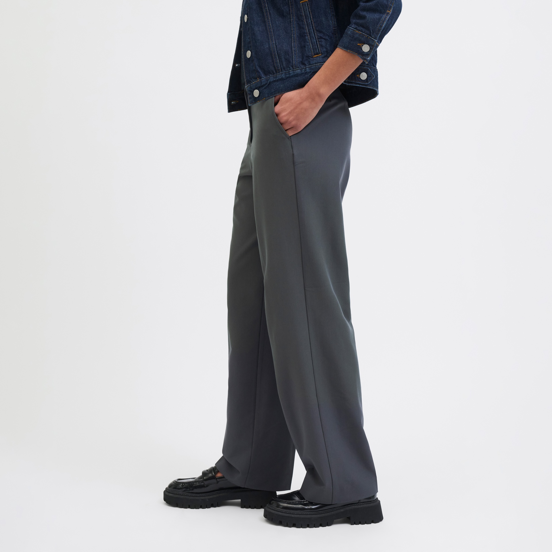 Calças cinza largas com casaco de ganga azul escuro e sapatos pretos