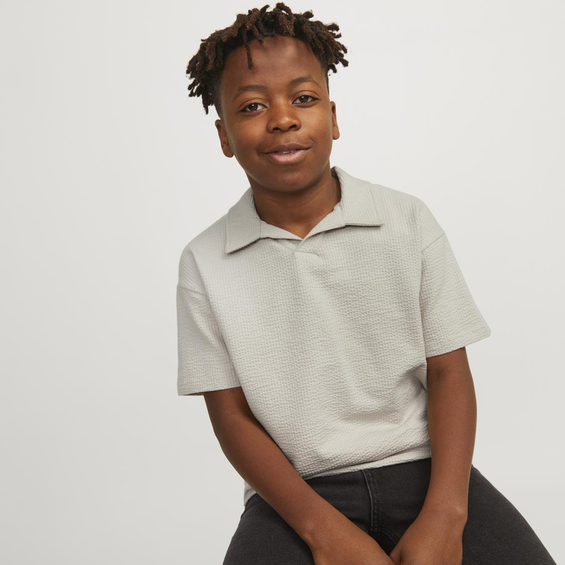 Camisola cinzenta clara texturizada de manga curta com camisa mulher sentada