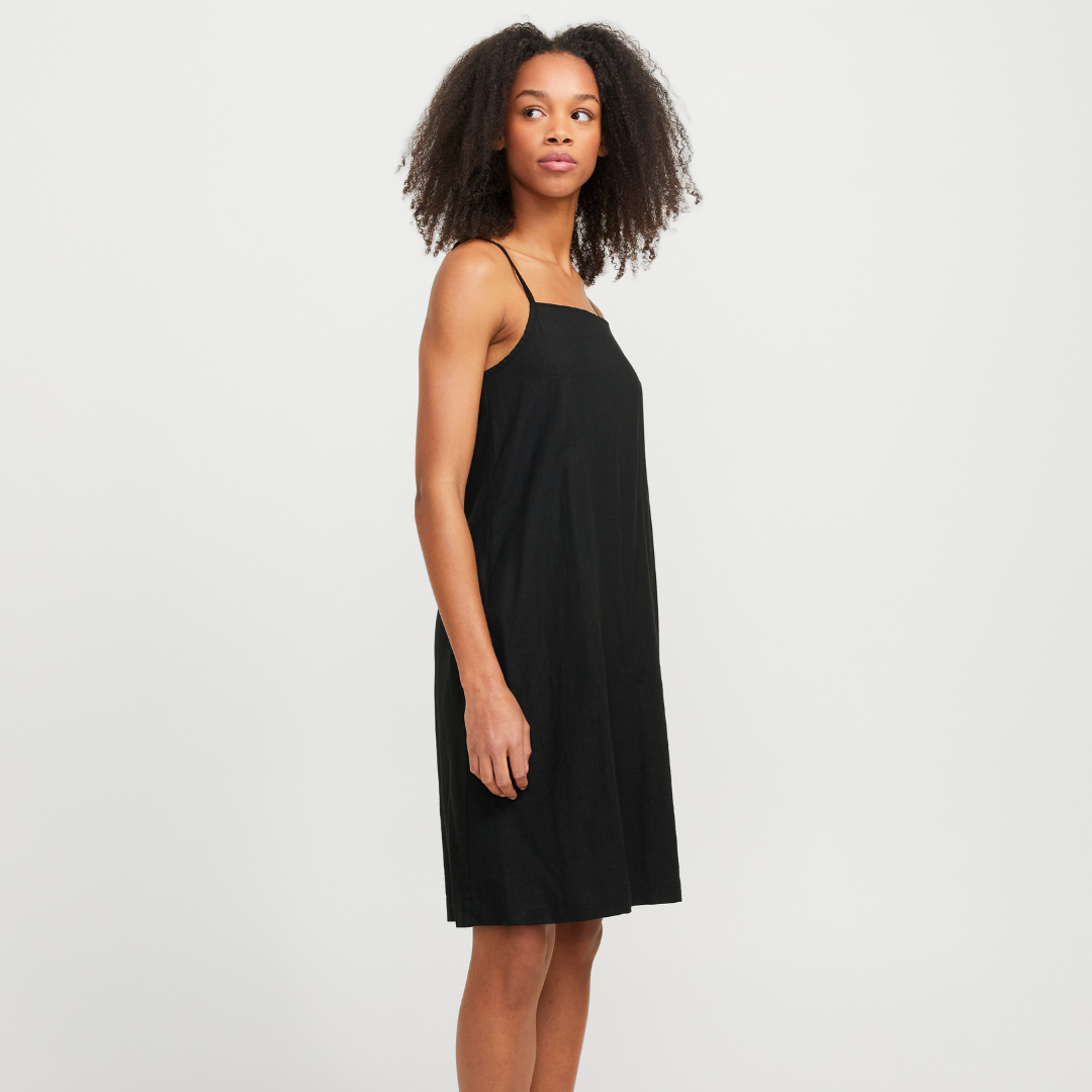 Vestido preto liso com alças finas num fundo branco