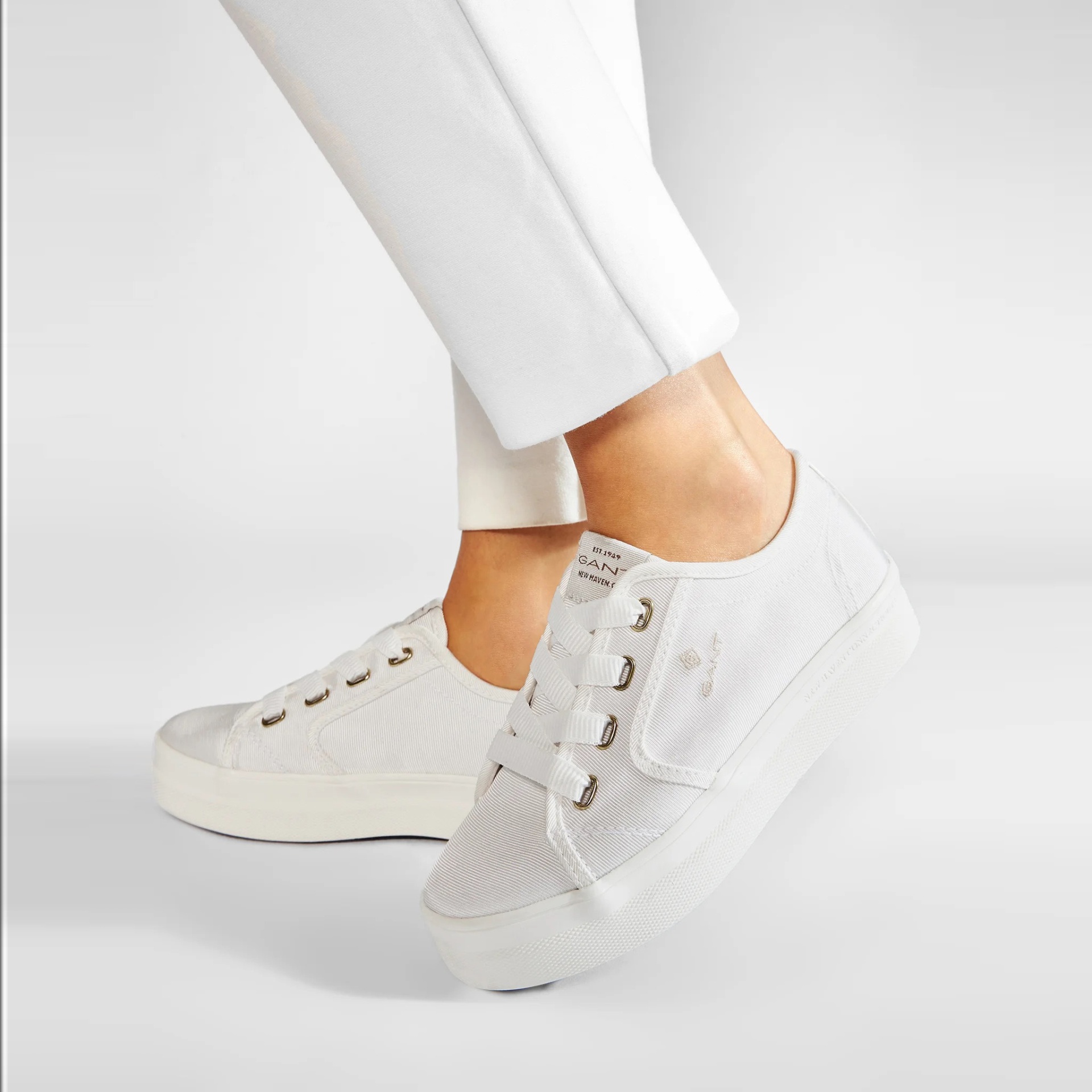 Ténis brancos de cabedal com atacadores elásticos e sola branca