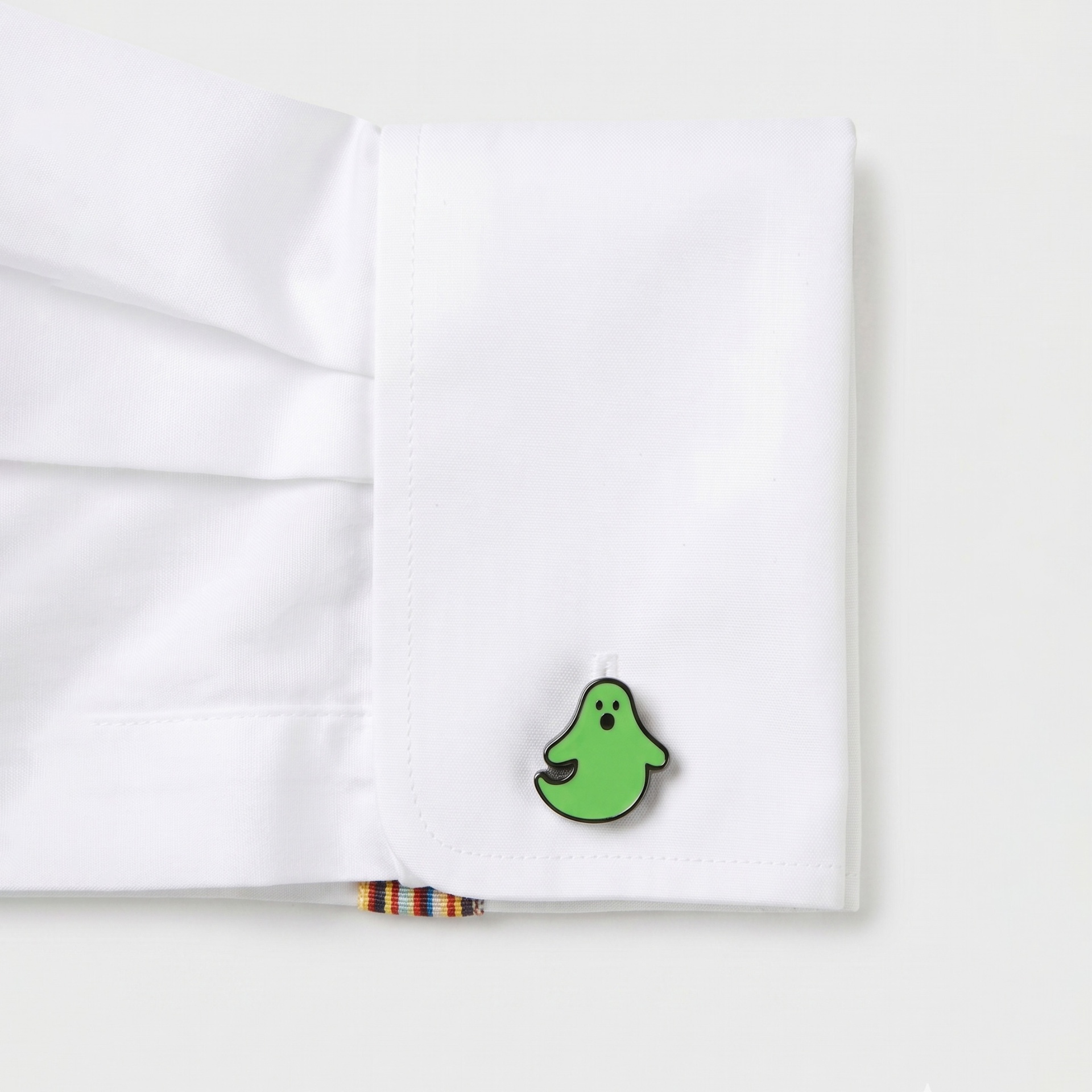 Manga de camisa branca com botão verde de fantasma e etiqueta listrada