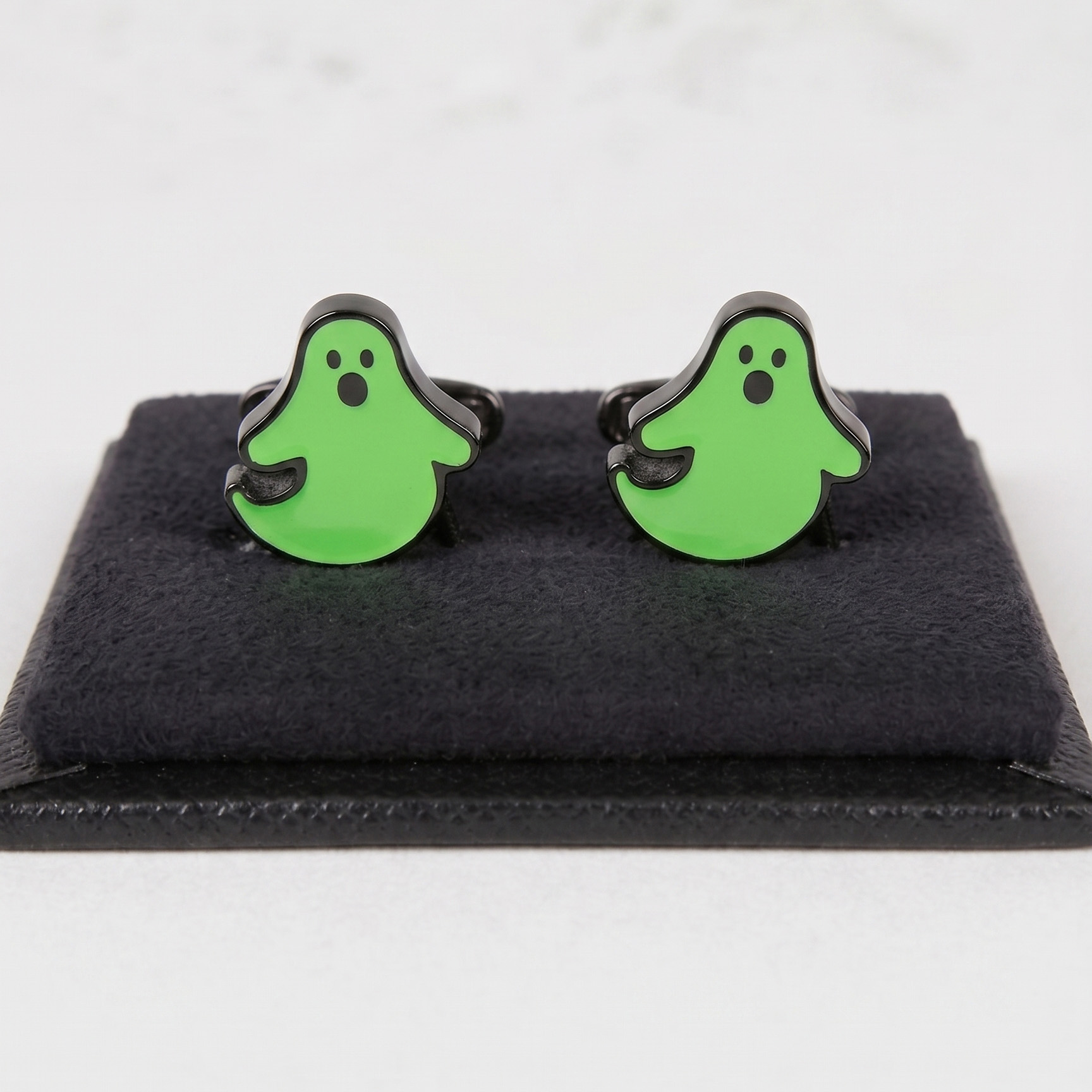 Botões de punho em forma de fantasma verde com olhos e boca pretos