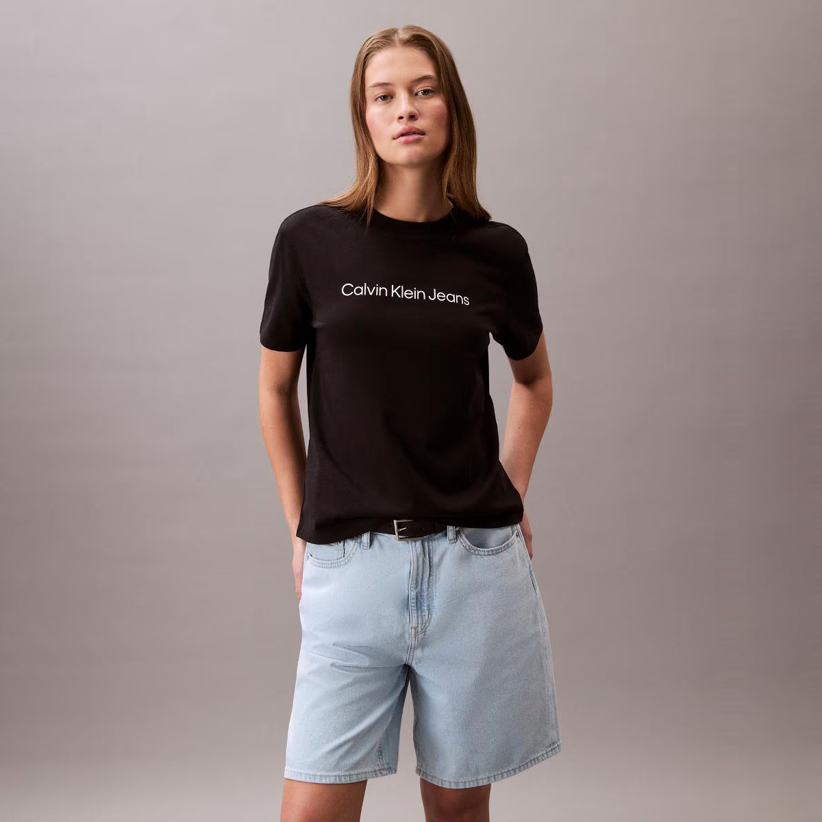 Modelo com t-shirt preta Calvin Klein Jeans e calções de ganga azuis claros