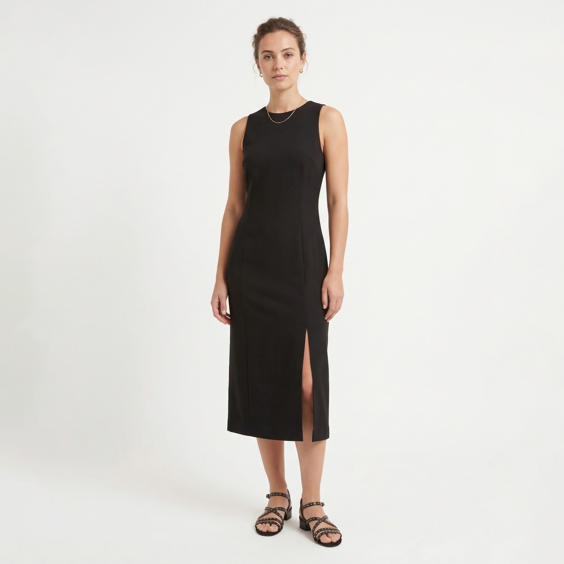 Vestido midi preto sem mangas com fenda lateral e sandálias pretas.
