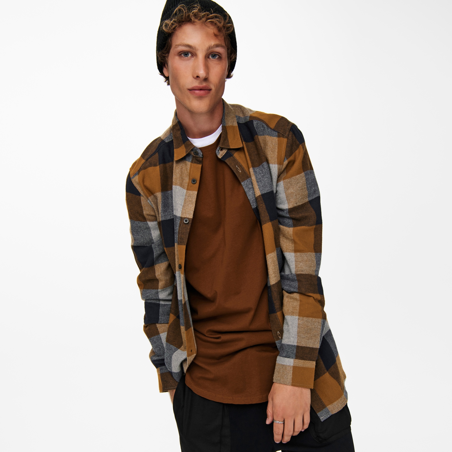Homem com camisa aos quadrados castanha, cinzenta e preta, camiseta castanha e gorro preto
