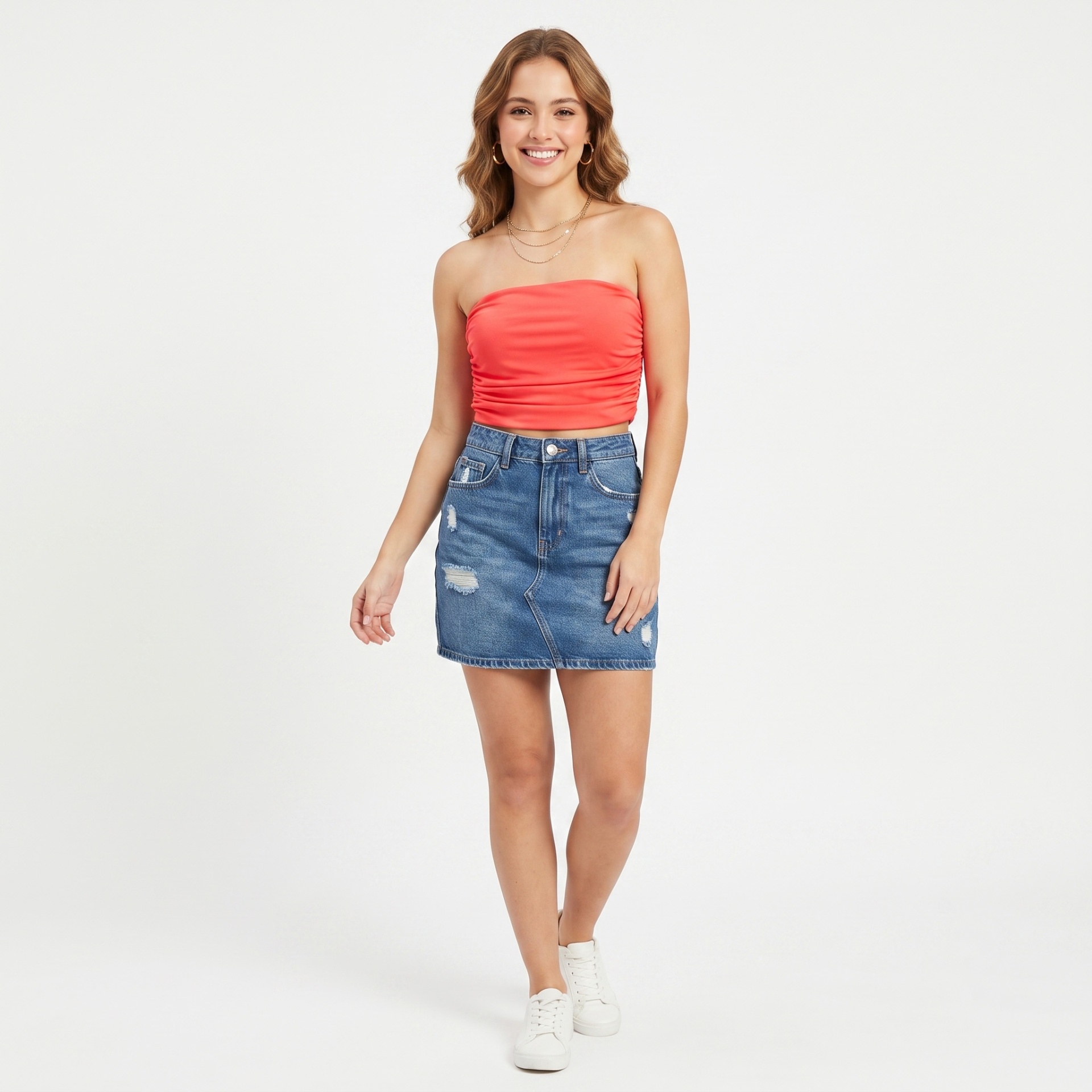 Mulher usando top coral e saia jeans curta