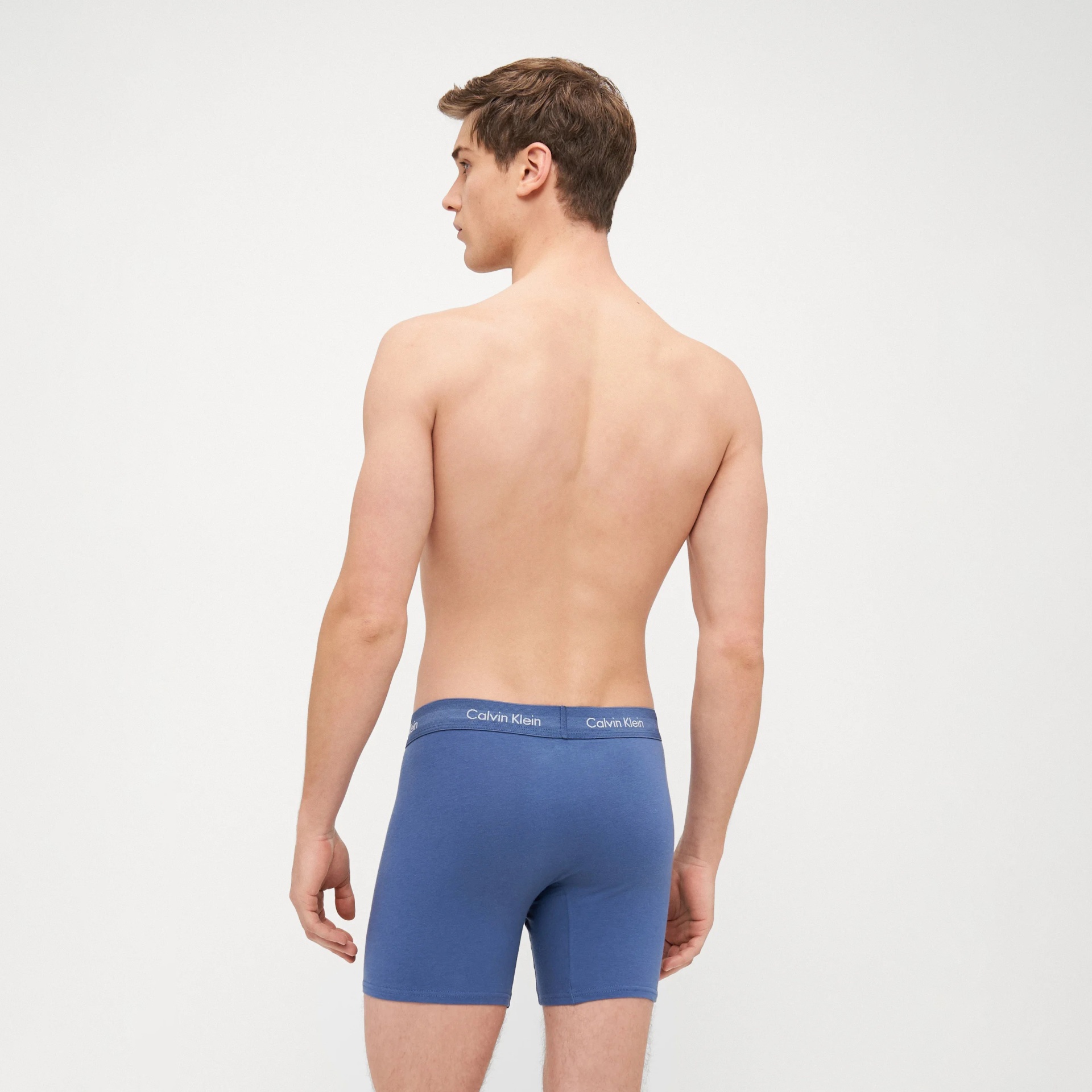 Rapaz de costas com boxers azuis Calvin Klein