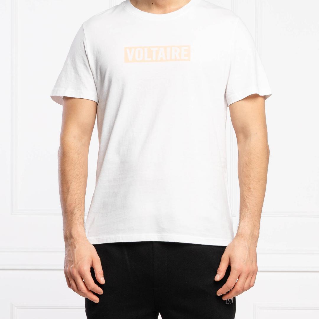 T-shirt branca com logo VOLTAIRE em pêssego no peito, vista frontal em modelo masculino