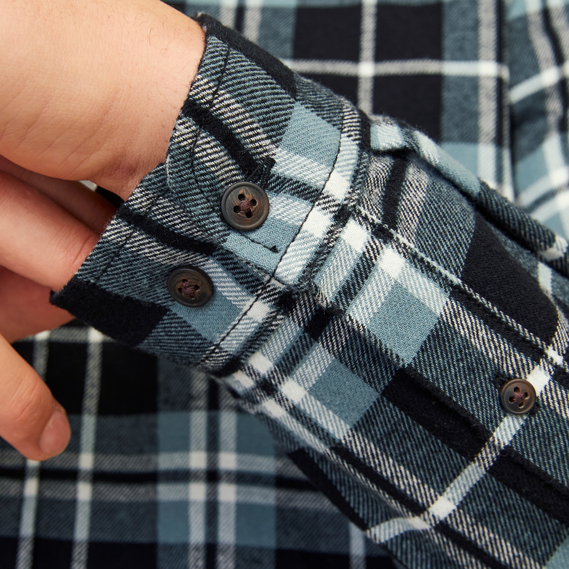 Camisa de flanela xadrez azul, preto e branco com punho e botões.