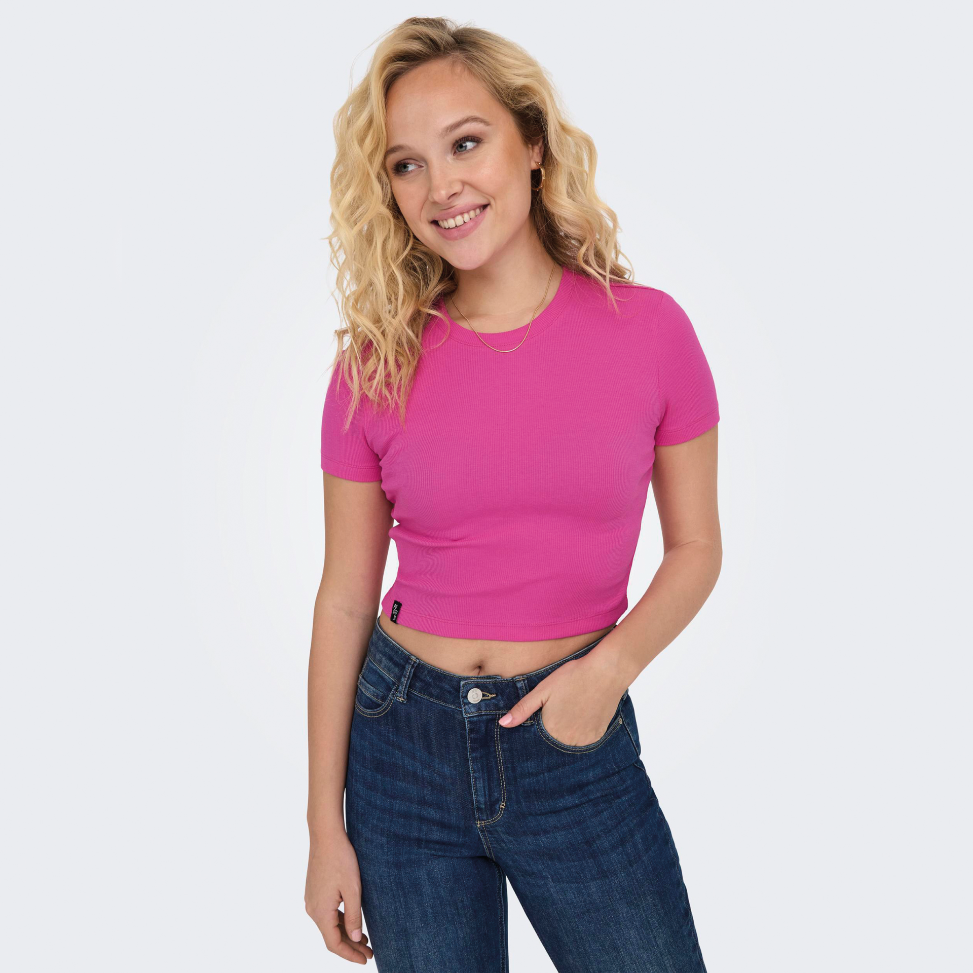 Mulher a usar camisola rosa de manga curta e calças de ganga azul