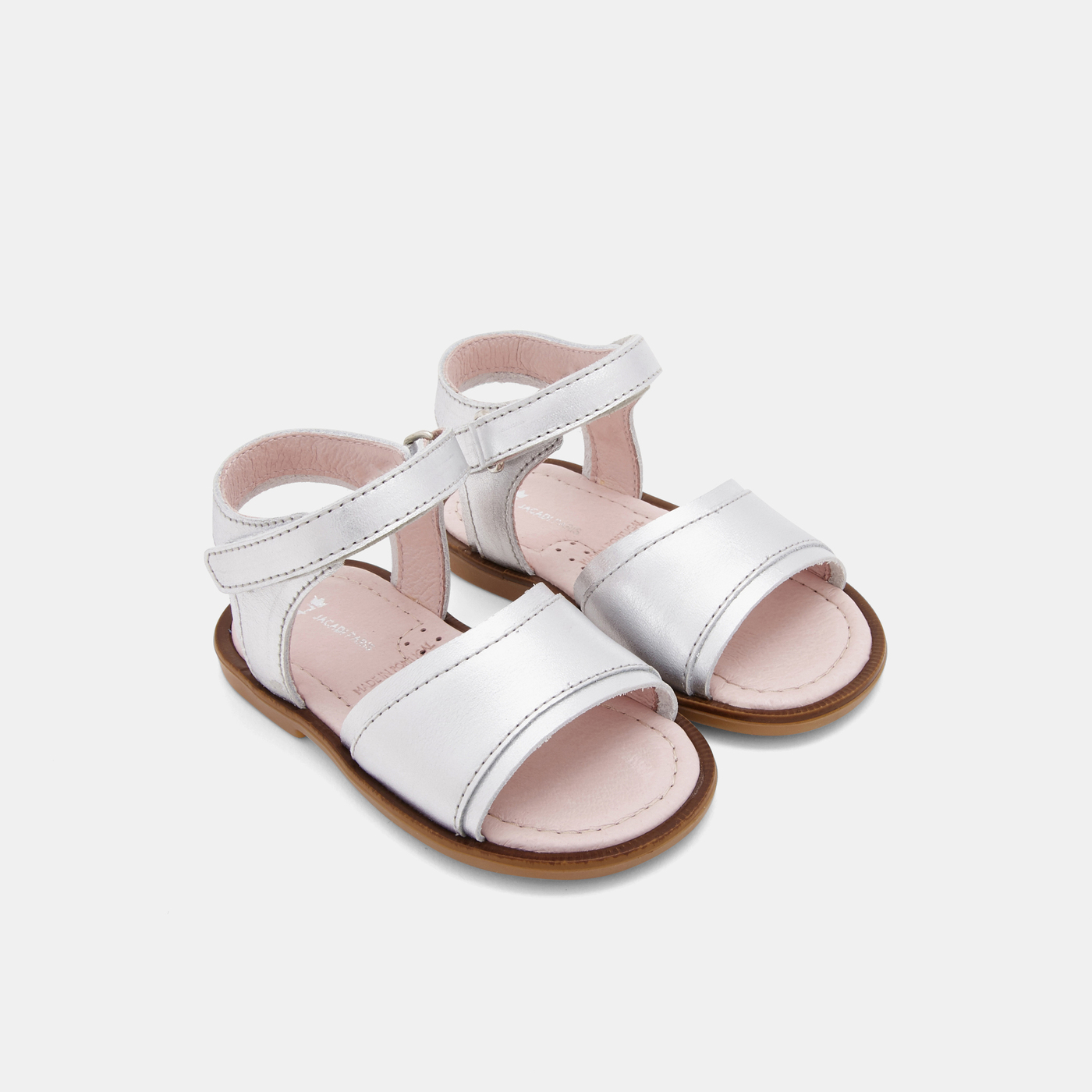 Sandálias infantis brancas com velcro e sola castanha.