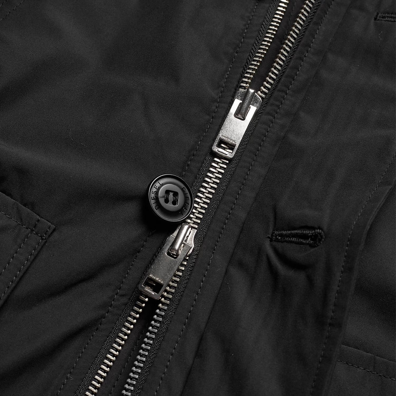 Fecho de correr metálico com botão preto em tecido preto de vestuário