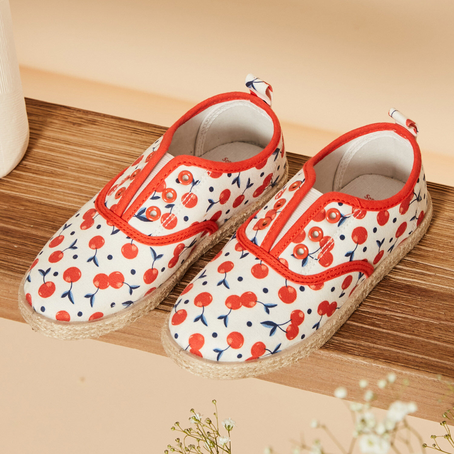 Sapatos infantis de lona com padrão de cerejas e acabamento vermelho