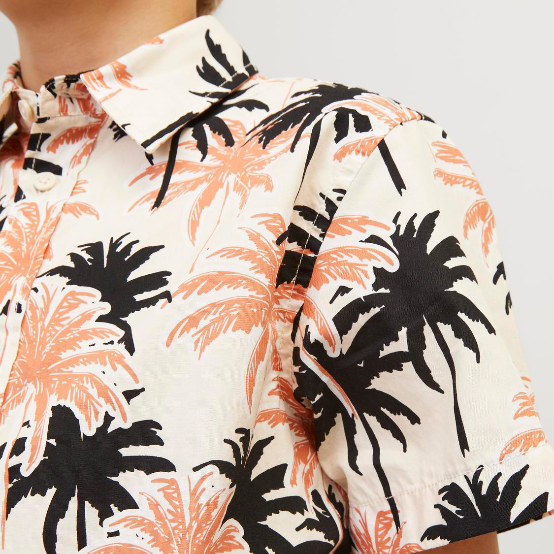 Camisa de manga curta com padrão de palmeiras em preto e cor de salmão