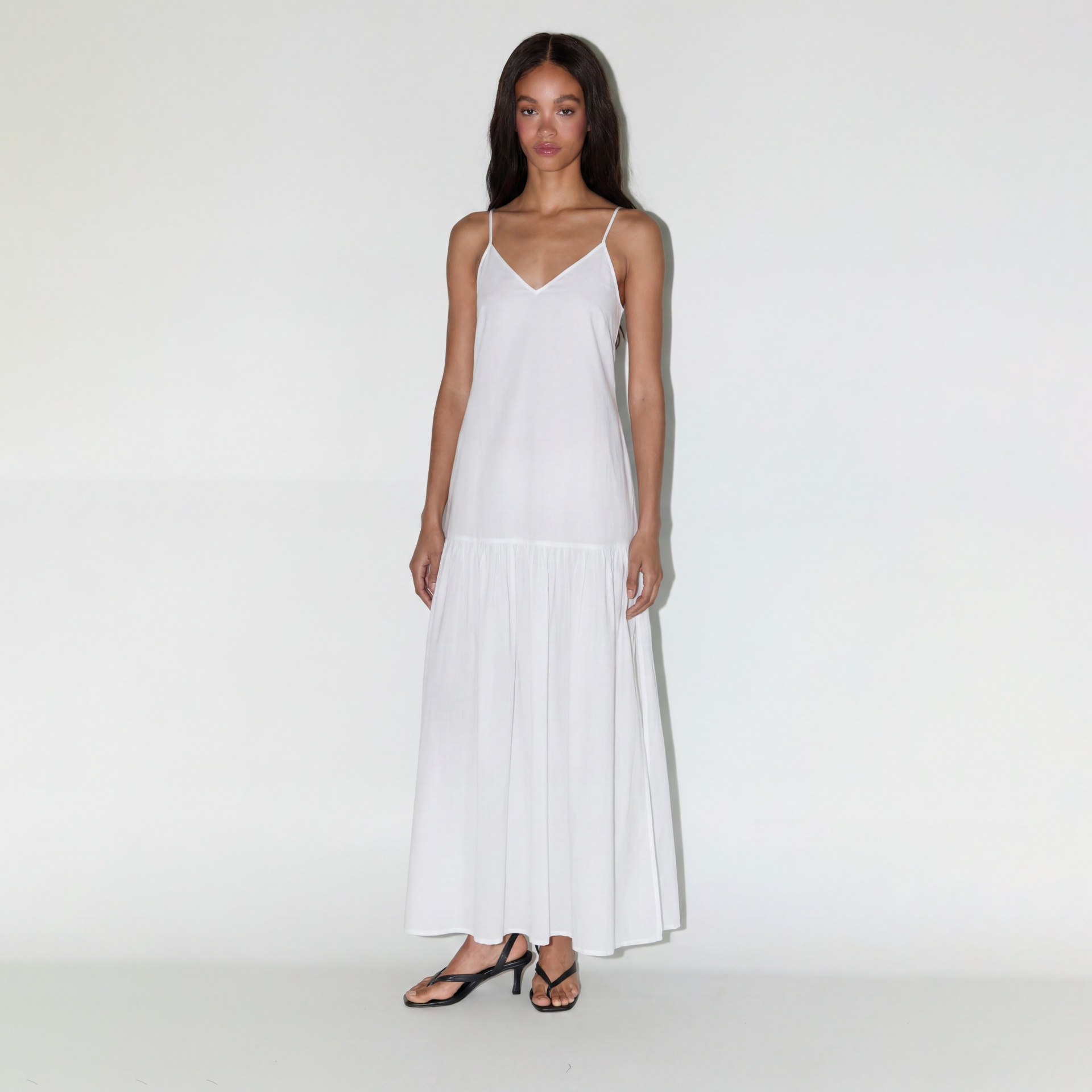 Vestido comprido branco com alças finas e sandálias pretas