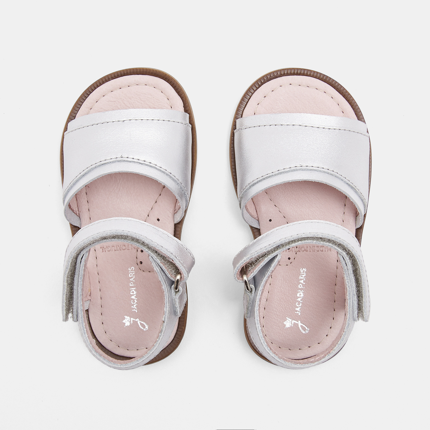 Sandálias infantis em pele branca com interior rosa e fecho de velcro.