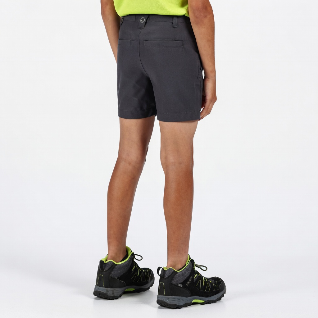 Calções pretos curtos usados por trás com t-shirt verde e botas de caminhada.