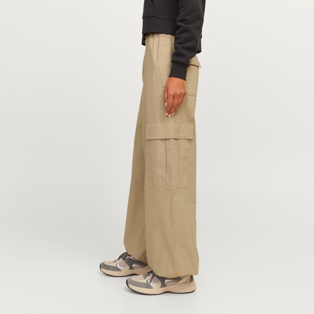 Calças largas bege com bolsos grandes laterais e sapatilhas