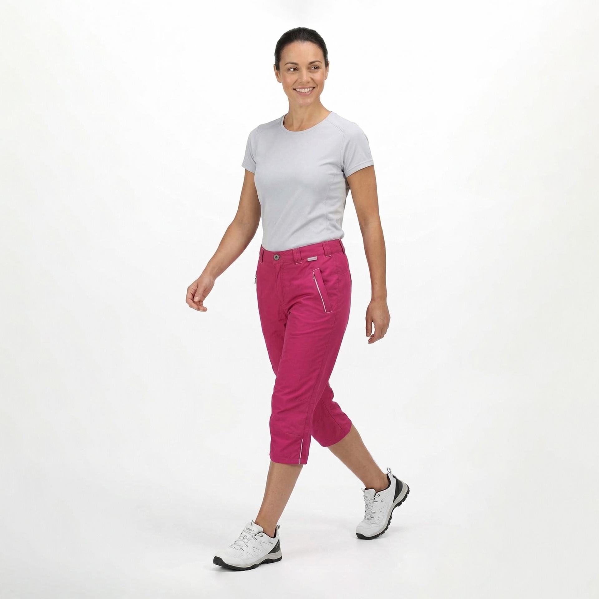 Mulher com camiseta cinza e calças capri cor de rosa a caminhar