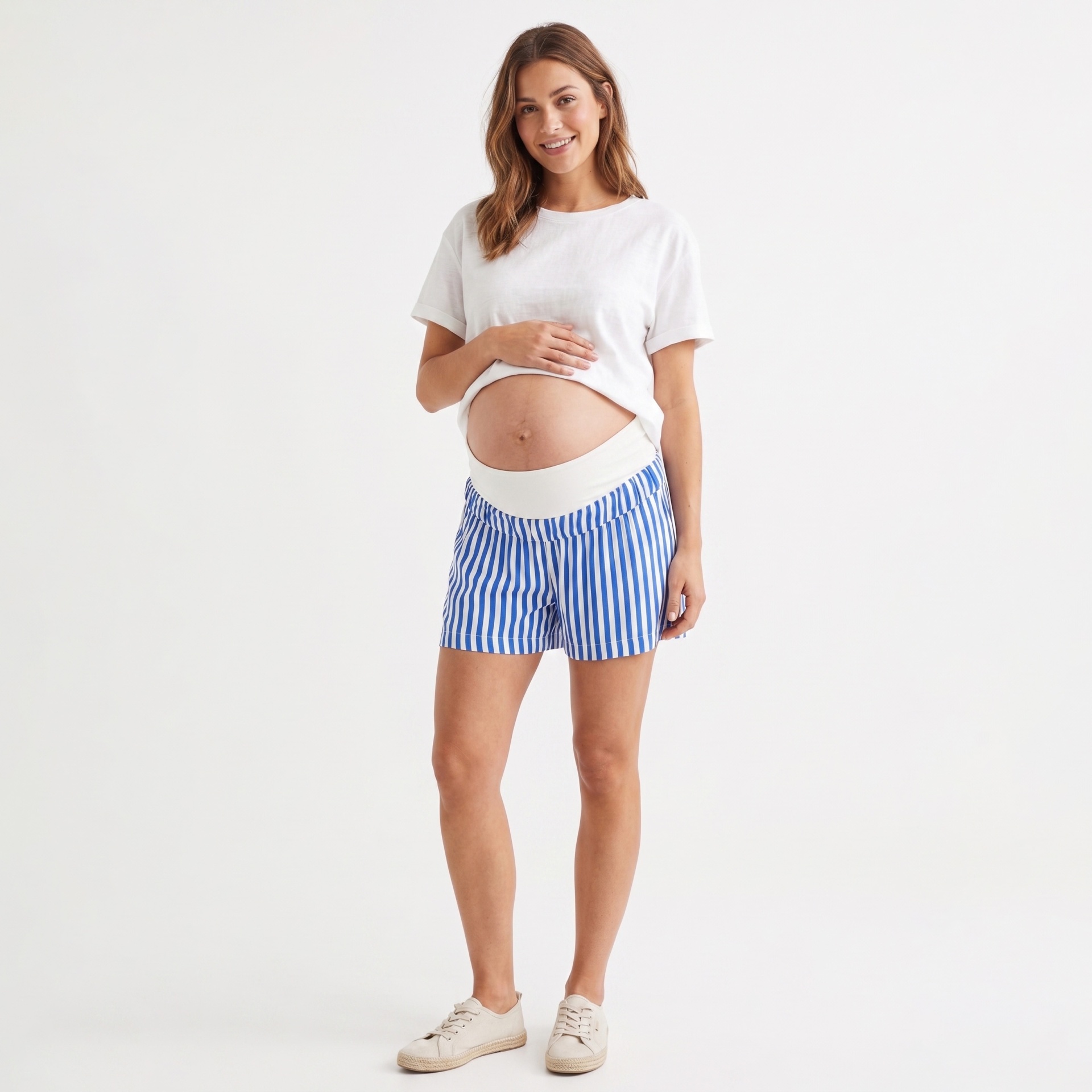 Mulher grávida com t-shirt branca e calções listrados azuis e brancos