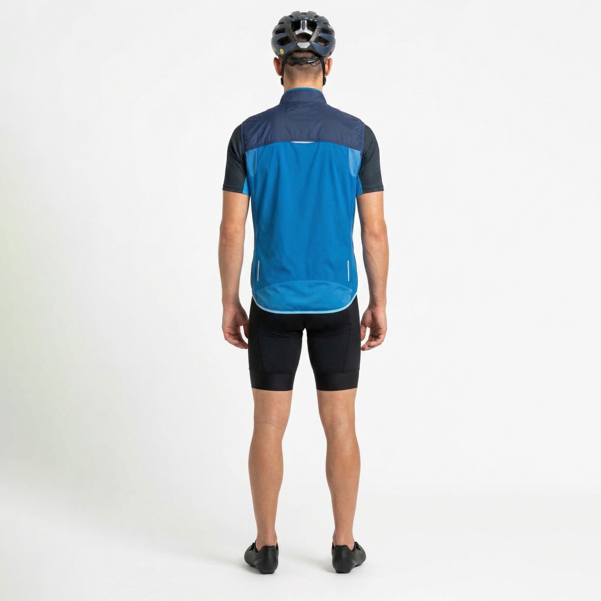 Homem de costas com colete azul, calções de ciclismo pretos e capacete preto