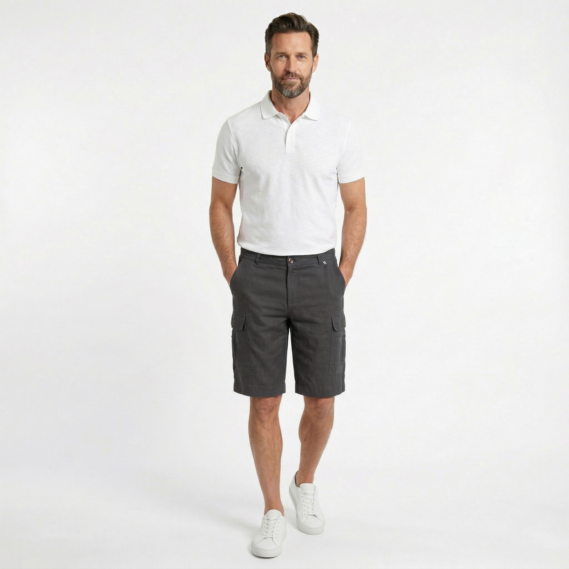 Homem com camisa polo branca, bermuda cinza escura e sapatos brancos