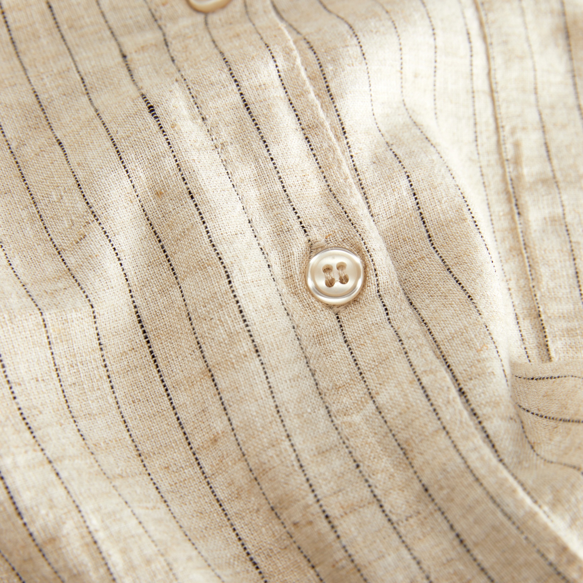 Tecido de camisa bege com riscas finas pretas e botões de madrepérola