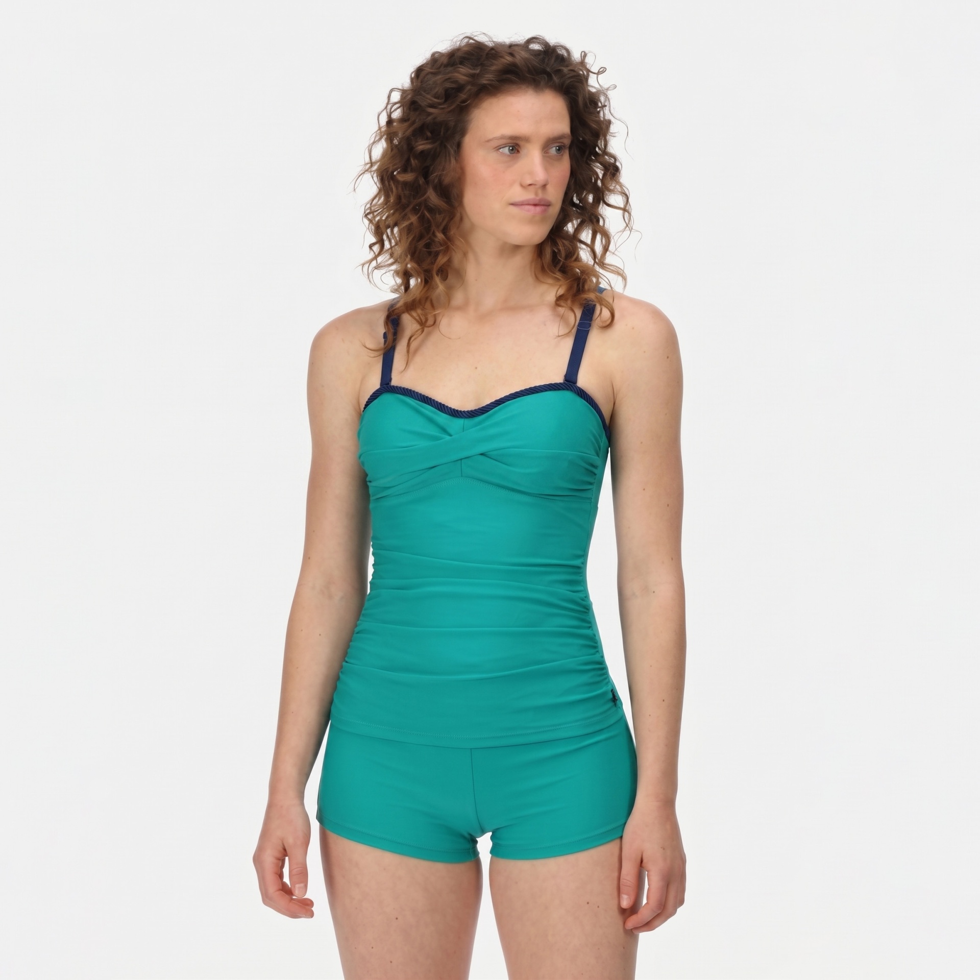 Fato de banho verde água com alças azuis e detalhe azul escuro, usado por mulher com cabelo encaracolado