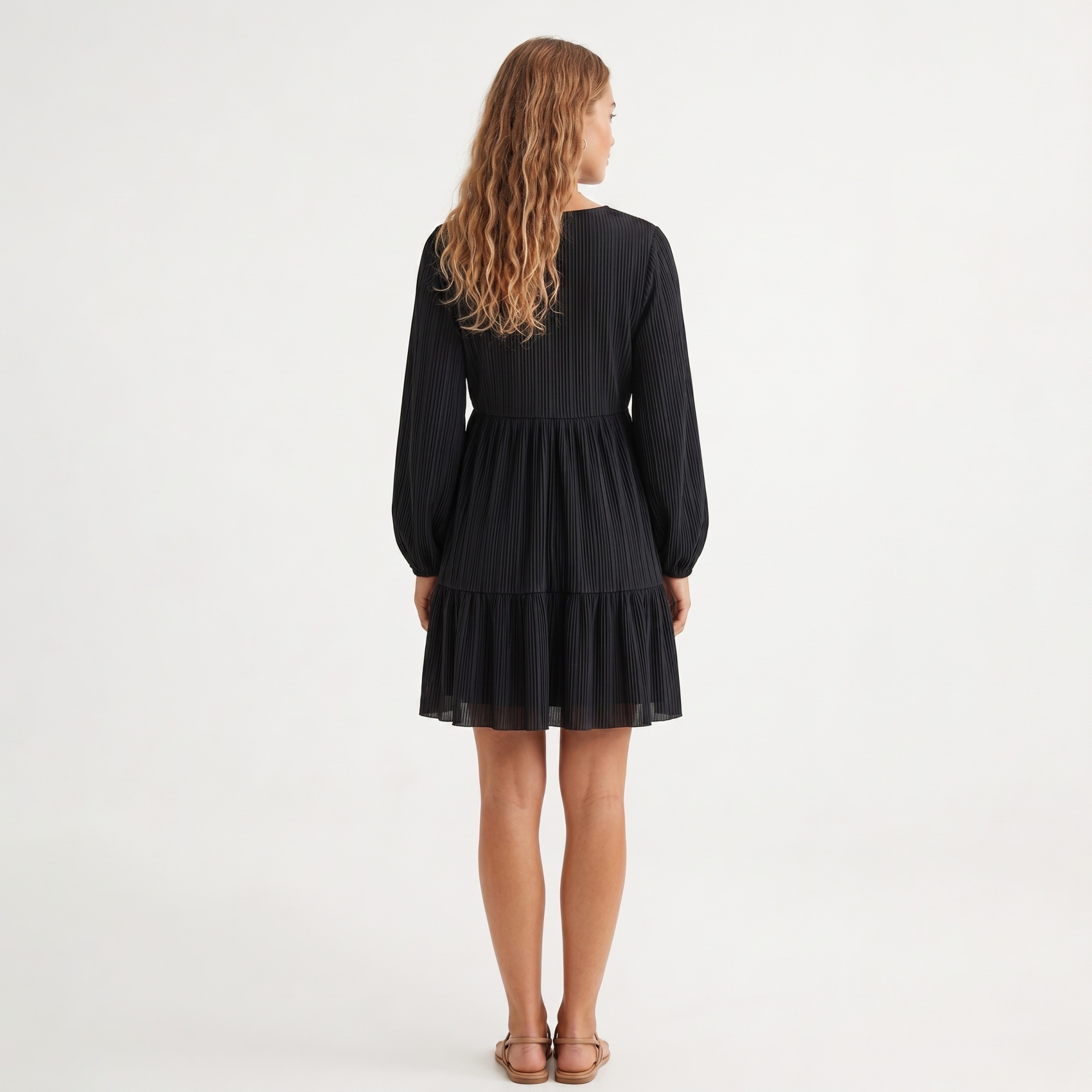 Vestido preto plissado feminino visto de costas.