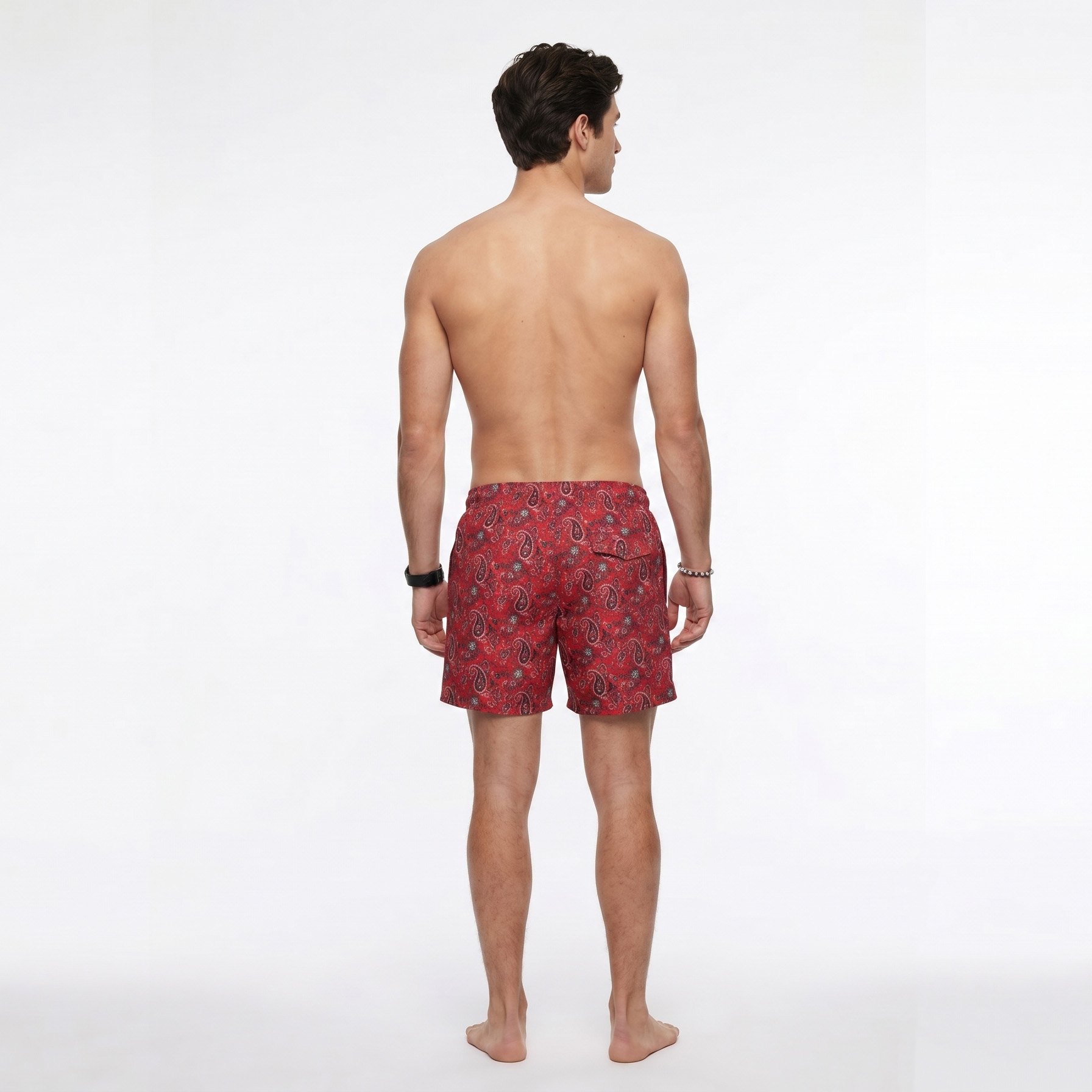 Vista de costas de homem com calções de banho vermelhos com padrão paisley