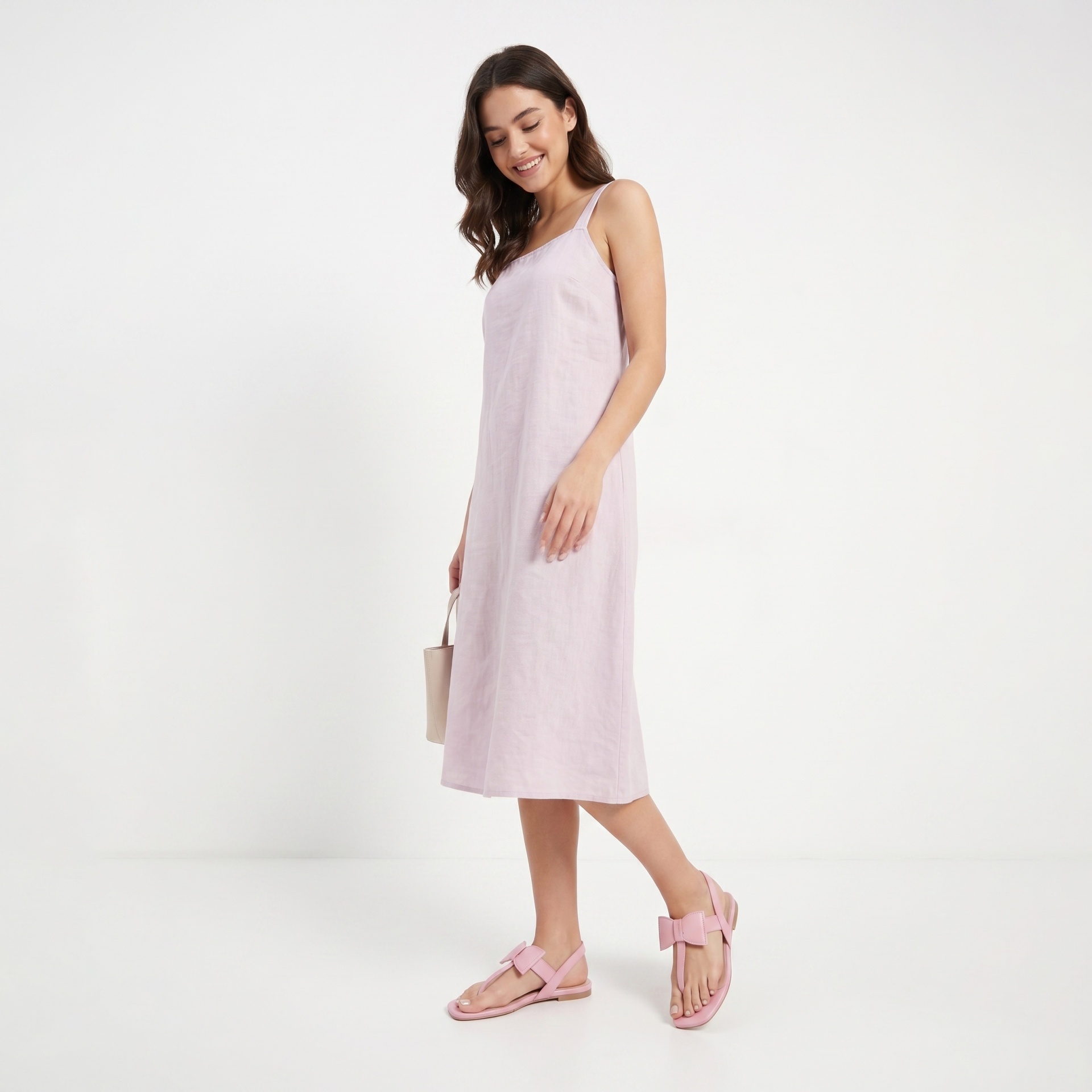 Mulher com vestido cor de rosa claro e sandálias rosa em fundo branco