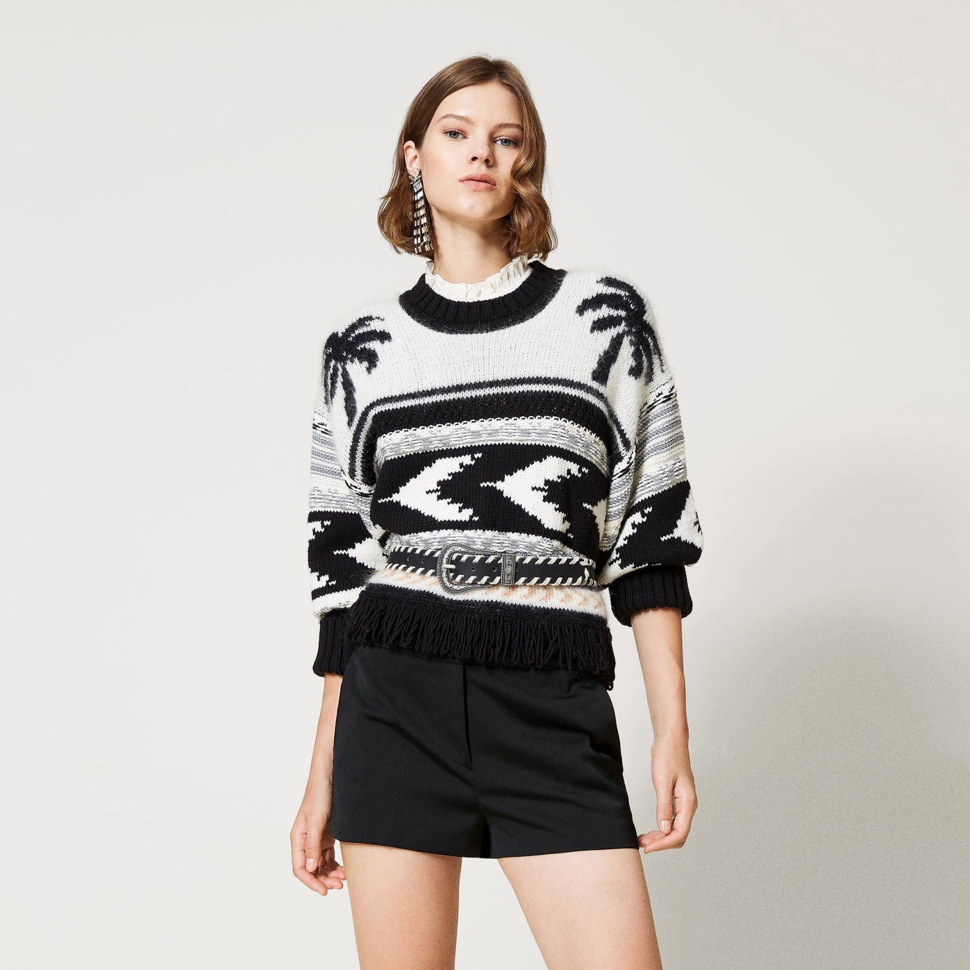 Mulher com camisola de tricô preta e branca e calções pretos