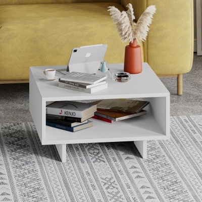 Mesa de centro branca com livros, tablet Apple e decoração em sala com sofá amarelo.