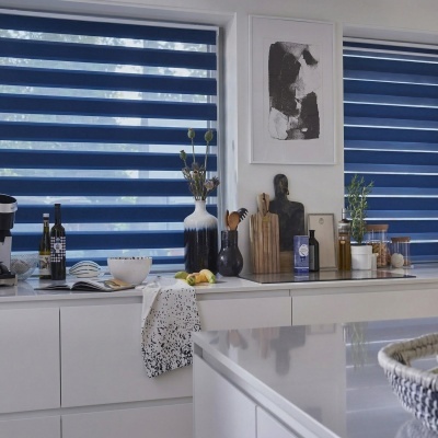 Cozinha moderna com estores em rolo duplo azul e acessórios no balcão branco