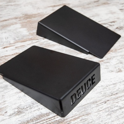 Duas caixas pretas retangulares, uma com a palavra DEUCE em relevo.