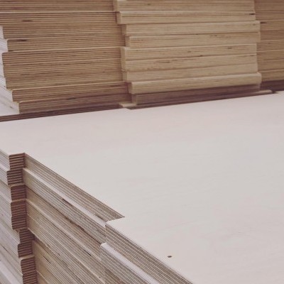 Pilhas de painéis de madeira clara empilhados num armazém