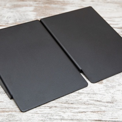 Capa preta para livro ou agenda aberta sobre mesa de madeira clara