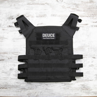 Colete tático preto DEUCE Tank Plate Carrier sobre fundo de madeira clara