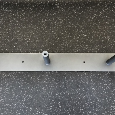 Suporte de parede metálico cinza com três ganchos e inscrição DEUCE