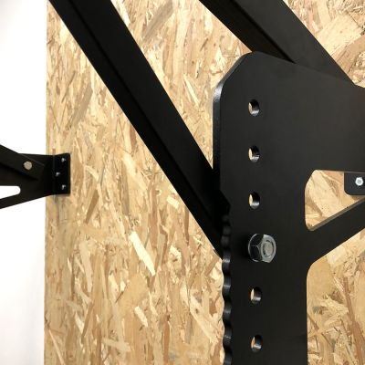 Estrutura metálica preta fixa numa parede de madeira aglomerada OSB