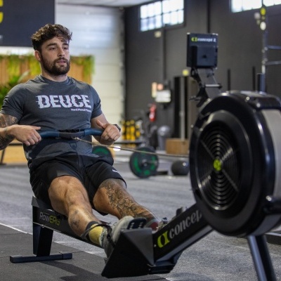 Homem a usar remo indoor Concept2 em ginásio.