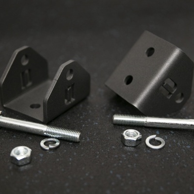 Suportes metálicos pretos com parafusos e porcas sobre superfície escura