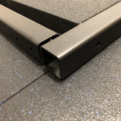 Encaixe de peças metálicas cinzentas num pavimento cinzento com reflexos azuis