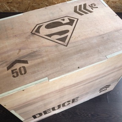 Caixa de madeira com logo do Superman e números gravados